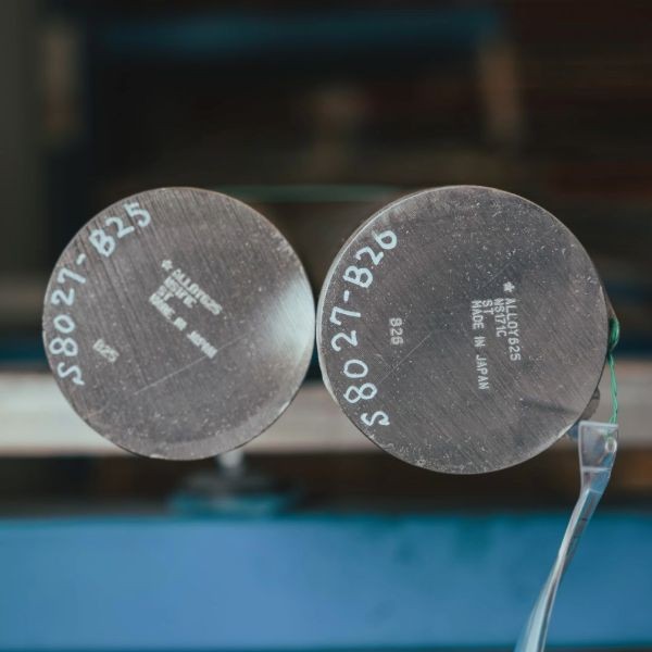 Two round metal bars with engraved markings.
