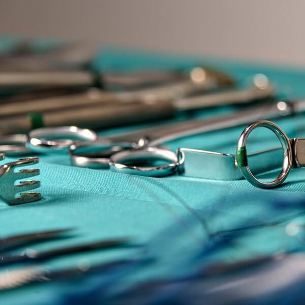 Stainless steel medical instruments arranged neatly on a table in a clinical setting.