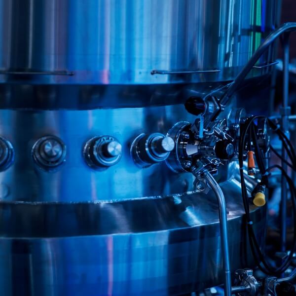 Close-up of stainless steel chemical processing equipment with pipes and valves.